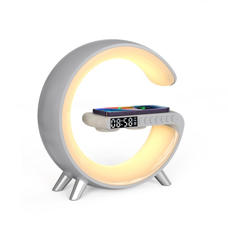 White G-shaped LED lamp with warm lighting and phone on charging pad